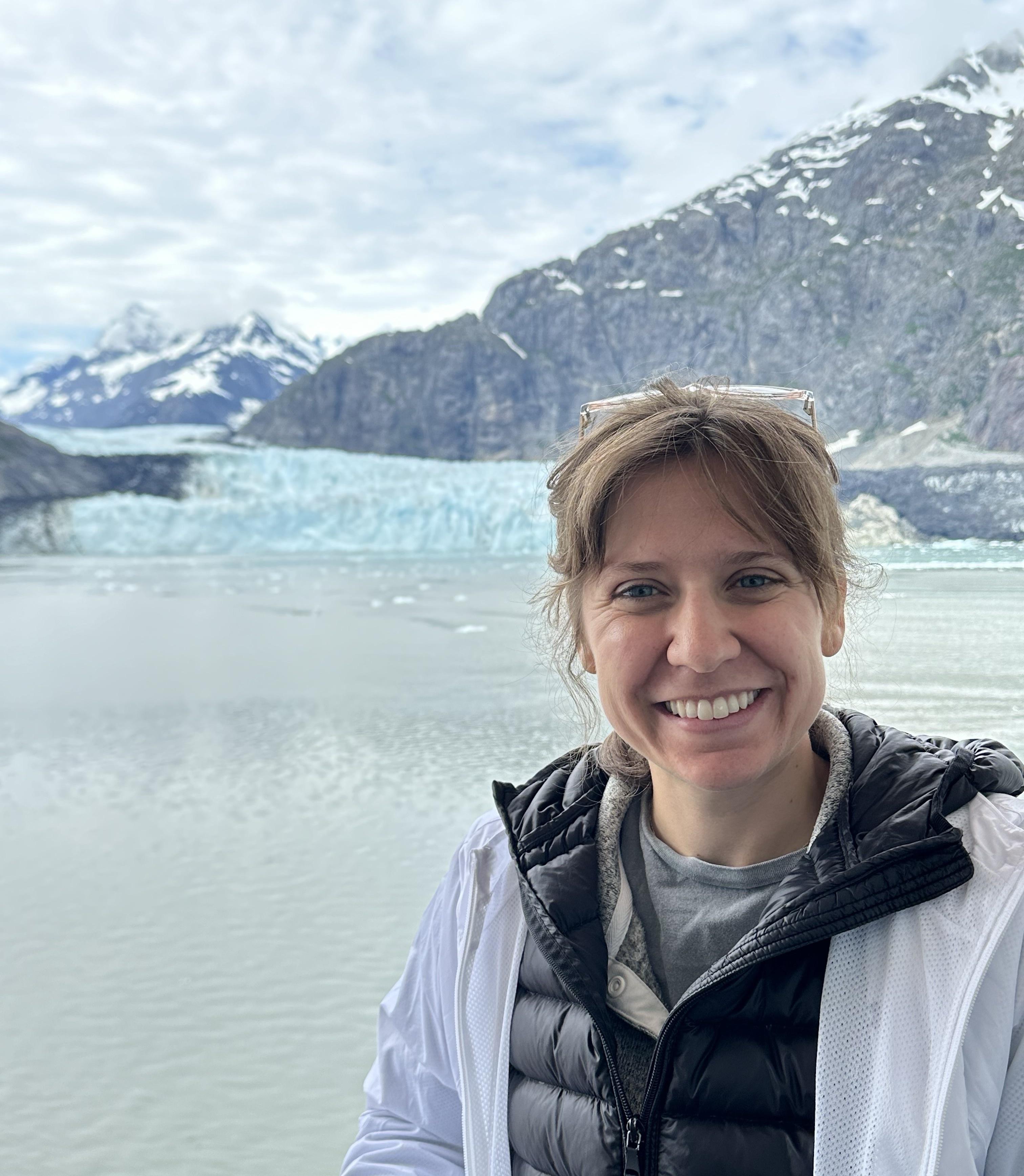 Megan Woodruff smiling in front of an Alaskan glacier